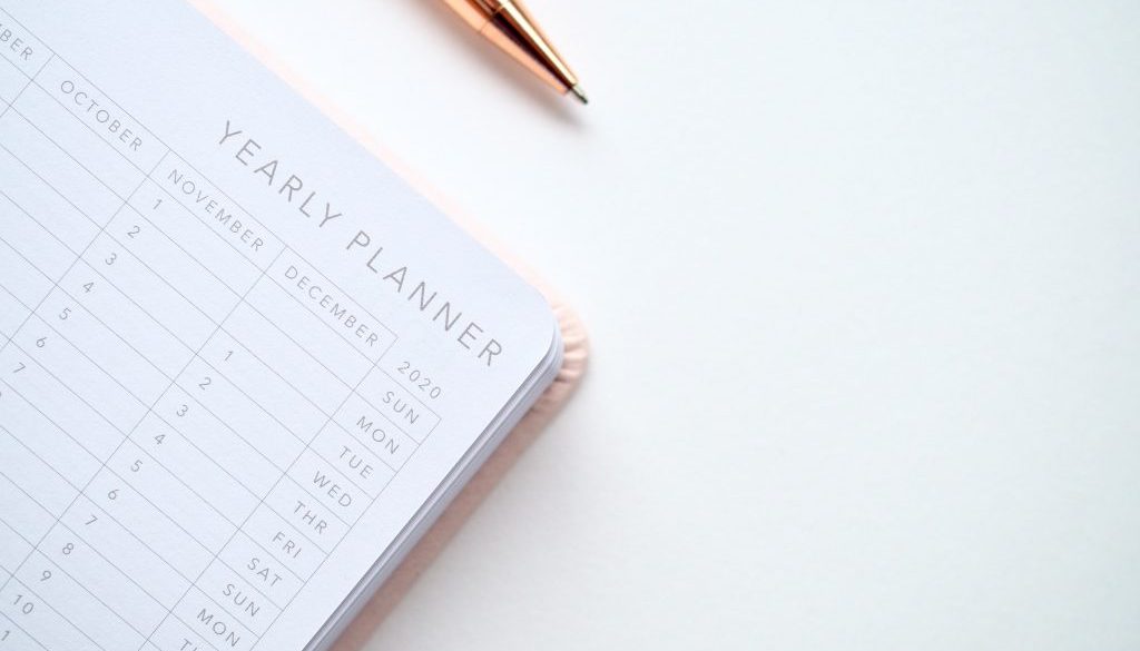 close-up-photo-of-yearly-planner-beside-a-pen-1558691